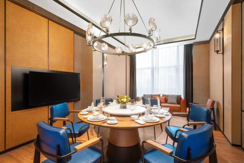 a dining room with a table and blue chairs at Four Points by Sheraton Chongqing, Yongchuan in Yongchuan