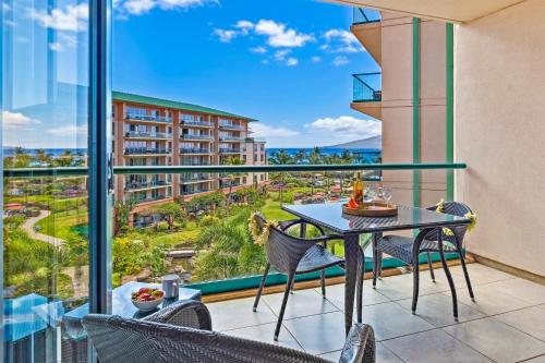 a balcony with a table and chairs and a view at HK #537 in Lahaina