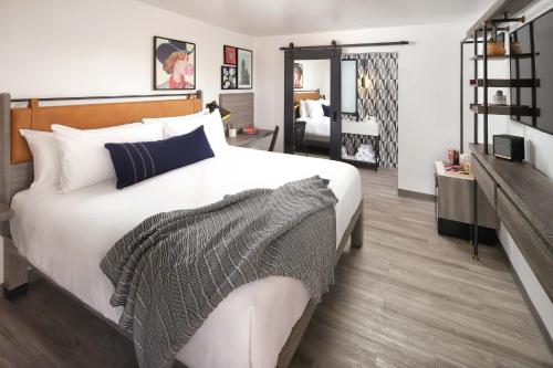 - une chambre avec un grand lit blanc et un canapé dans l'établissement The Tuxon Hotel, Tucson, a Member of Design Hotels, à Tucson