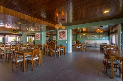 AquaHotel في أوفار: غرفة طعام مع طاولات وكراسي خشبية