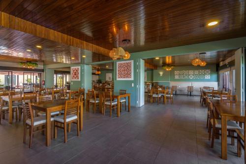 uma sala de jantar com mesas e cadeiras de madeira em AquaHotel em Ovar