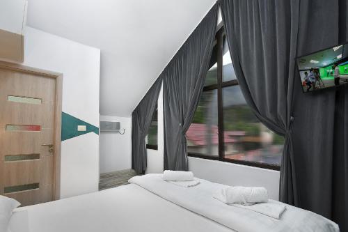 a bedroom with two beds and a window with a tv at Impressive Târgu Ocna in Târgu Ocna