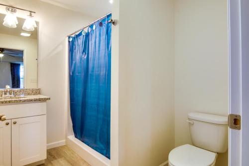 a bathroom with a toilet and a blue shower curtain at Rehoboth Beach Vacation Rental with Community Pool! in Rehoboth Beach
