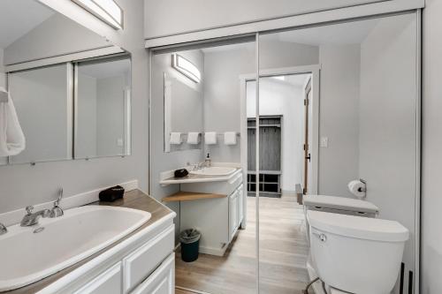 Baño blanco con 2 lavabos y aseo en Fletcher Bay Overlook, en Fletcher Bay