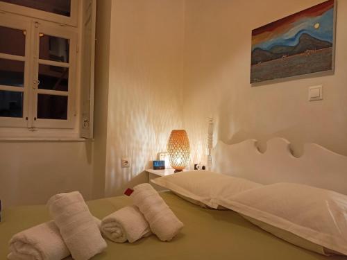 a bedroom with towels on a bed with a window at Hydra Memories House in Hydra