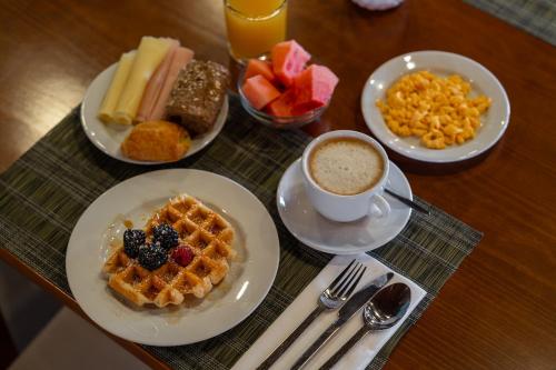 a table with plates of breakfast food and a cup of coffee at AquaHotel in Ovar