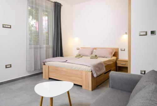 スプリトにあるApartment Delalleのベッドと椅子とソファのある寝室