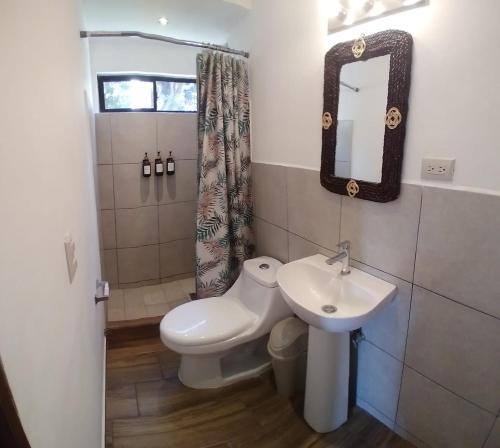 a bathroom with a sink and a toilet and a mirror at Hotel María Isabel Ataco in Concepción de Ataco