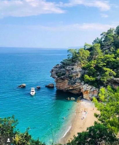 una vista di una spiaggia con una barca in acqua di BİLGE PANSİYON a Antalya (Adalia)