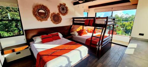 康塞普西翁德阿塔科的住宿－Hotel María Isabel Ataco，一间卧室设有两张双层床和一扇窗户。