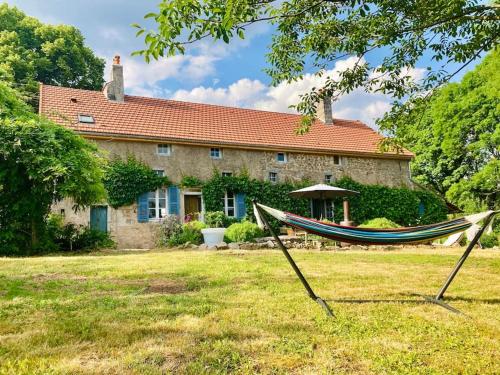 una hamaca frente a una casa de piedra en Ruime woning in de Morvan, Bourgogne met seizoensgebonden zwembad, en Brassy