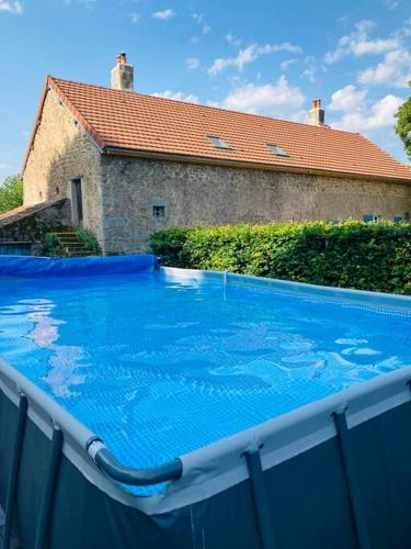 une grande piscine bleue devant une maison dans l'établissement Ruime woning in de Morvan, Bourgogne met seizoensgebonden zwembad, à Brassy