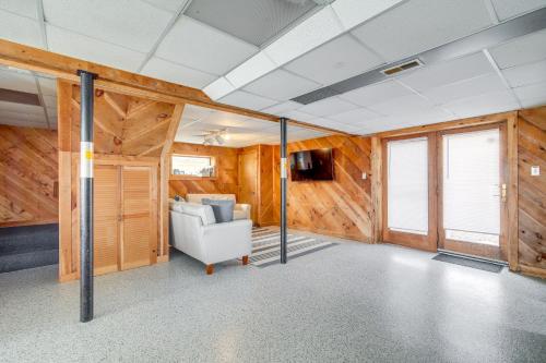 a living room with wooden walls and a white couch at Serene Mattapoisett Home with Private Beach Access! in Mattapoisett