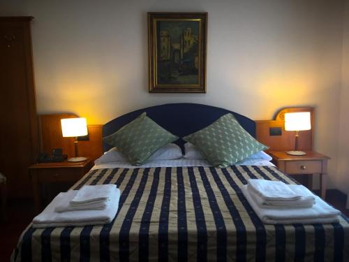 1 dormitorio con 1 cama con almohadas y 2 lámparas en Erania, en Sala Consilina