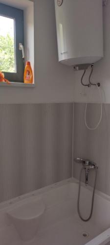 baño con ducha, lavabo y ventana en Atpūtas vieta ar pirti en Ventspils