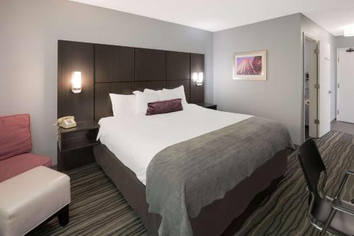 Pokój hotelowy z dużym łóżkiem i krzesłem w obiekcie Best Western Riverside Inn w mieście Danville