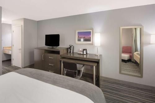 Habitación de hotel con cama y escritorio con TV. en Best Western Riverside Inn en Danville