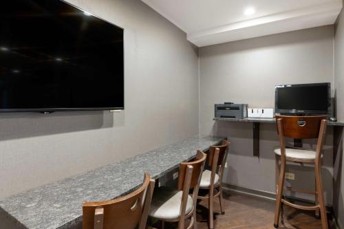 a room with a bar with chairs and a flat screen tv at Best Western University Inn at Valparaiso in Valparaiso