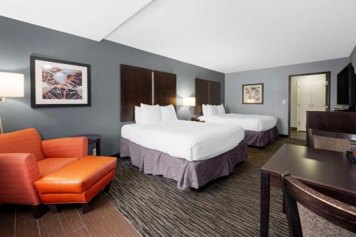 una habitación de hotel con 2 camas y una silla en Best Western University Inn at Valparaiso, en Valparaiso