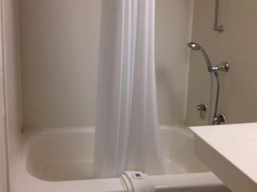 y baño con ducha con cortina blanca. en Motel 6-Monroe, LA, en Monroe