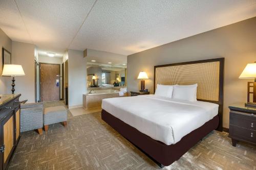a hotel room with a large bed and a bathroom at Best Western Detroit Livonia in Livonia
