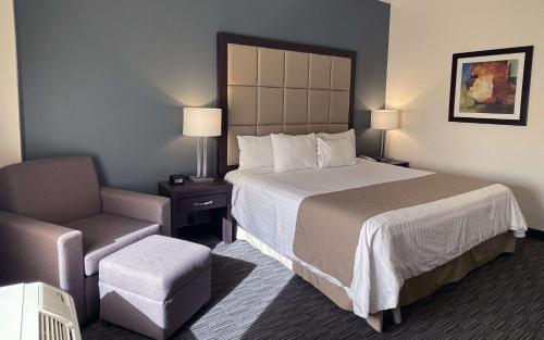 a hotel room with a bed and a chair at Best Western Plus Chihuahua Juventud in Chihuahua