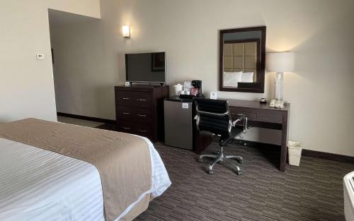 a hotel room with a bed and a desk with a computer at Best Western Plus Chihuahua Juventud in Chihuahua