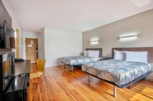 two beds in a room with wooden floors at Motel 6-Springfield, OH in Springfield