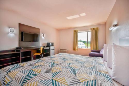 um quarto de hotel com uma cama grande e uma secretária em Motel 6-Springfield, OH em Springfield