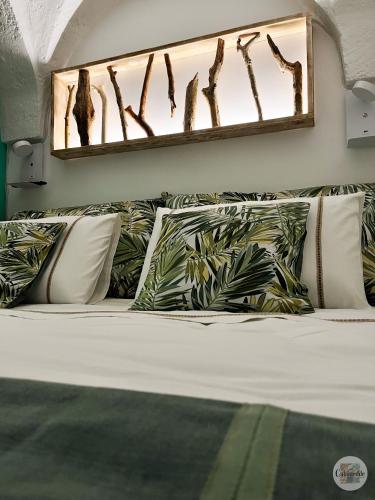 1 cama con almohadas y espejo en la pared en Calamedde Guest House nel Centro Storico Pugliese en Fasano