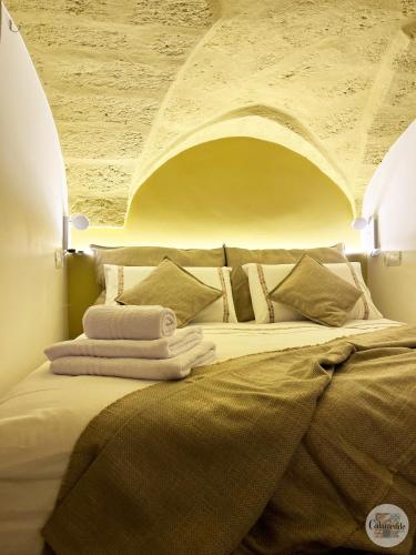 sypialnia z dużym łóżkiem z łukiem powyżej w obiekcie Calamedde Guest House nel Centro Storico Pugliese w mieście Fasano