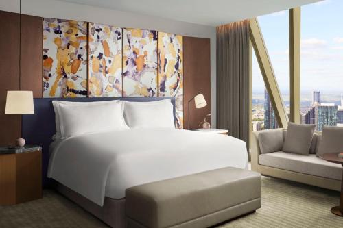 a bedroom with a large white bed and a couch at The Ritz-Carlton, Melbourne in Melbourne