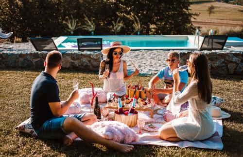 a group of people sitting on a picnic blanket at Holiday House Sunset Spa in Šentjernej