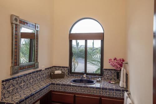 a bathroom with a sink and two mirrors at Rancho Las Cruces in Las Cruces