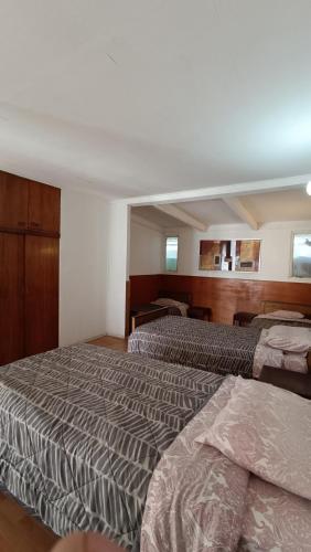 um quarto de hotel com duas camas e duas janelas em Residencial familiar El Valle em Copiapó