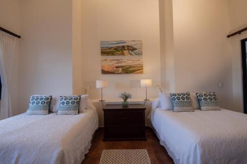 a bedroom with two beds and a table with lamps at Rancho Las Cruces in Las Cruces