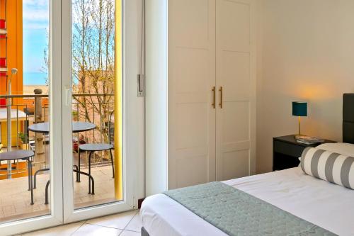 a bedroom with a bed and a balcony at APPARTAMENTI LEONE - Vista Mare in Rimini