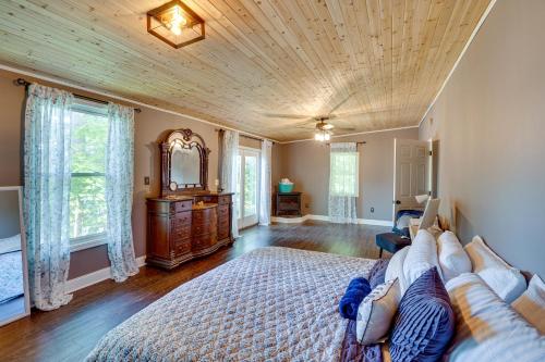 Großes Zimmer mit einem Bett und einem Spiegel in der Unterkunft Lakefront West Sand Lake Home with Beach Access! 