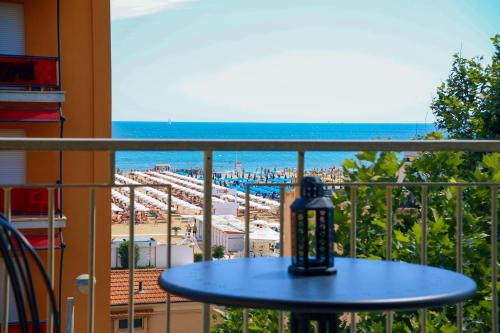 balcón con mesa y vistas a la playa en APPARTAMENTI LEONE - Vista Mare Rimini, en Rímini