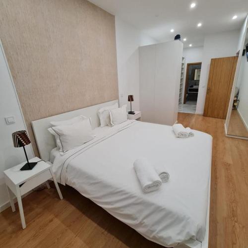 a white bedroom with a large white bed with white pillows at Kubata T1 in Parede