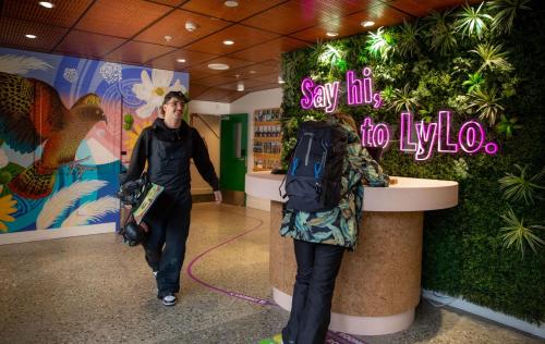 a man and a woman walking down a hallway at LyLo Queenstown in Queenstown