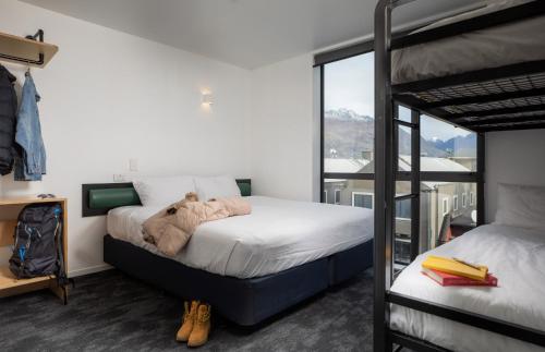 a bedroom with two bunk beds and a balcony at LyLo Queenstown in Queenstown