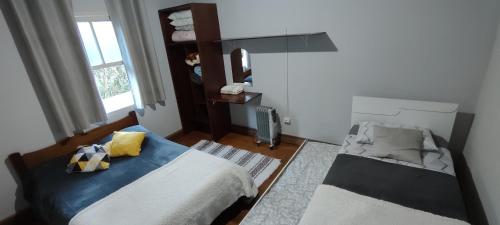 a bedroom with two beds and a window at Recanto Dorinha in Campos do Jordão