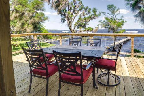 a table and chairs on a deck with a view of the water at Renovated Crescent Lake Escape with Waterfront Deck! in Crescent City