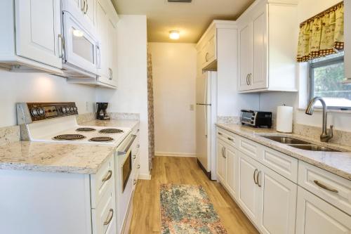 a kitchen with white cabinets and a sink at Renovated Crescent Lake Escape with Waterfront Deck! in Crescent City