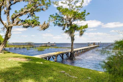 a dock on the water with trees in the foreground at Renovated Crescent Lake Escape with Waterfront Deck! in Crescent City
