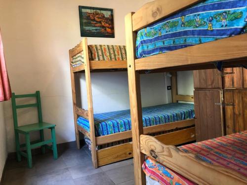 a bedroom with two bunk beds and a chair at Puerto Nómade Hostel Internacional in Mar del Plata