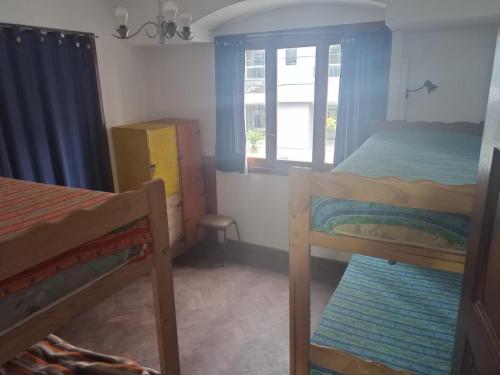 1 dormitorio con 2 literas y ventana en Puerto Nómade Hostel Internacional en Mar del Plata