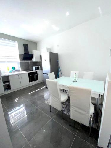 a kitchen with a white table and white chairs at appartement douvres in Brussels