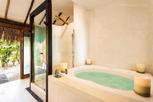 ein Bad mit einer Badewanne und einem Fenster in der Unterkunft Beachfront suites in Tulum beach in Tulum
